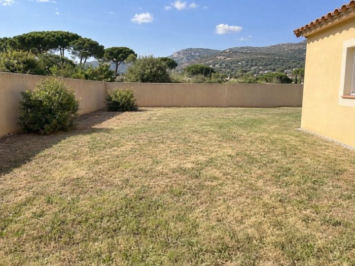Avant : le jardin d'une villa du Midi, une pelouse sèche le long d'un mur. Image générée par IA.